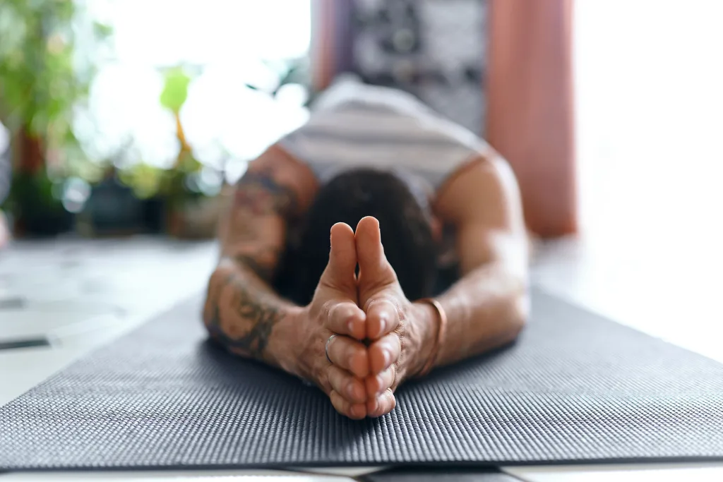 grounded morning routine man doing yoga practice in hotel room